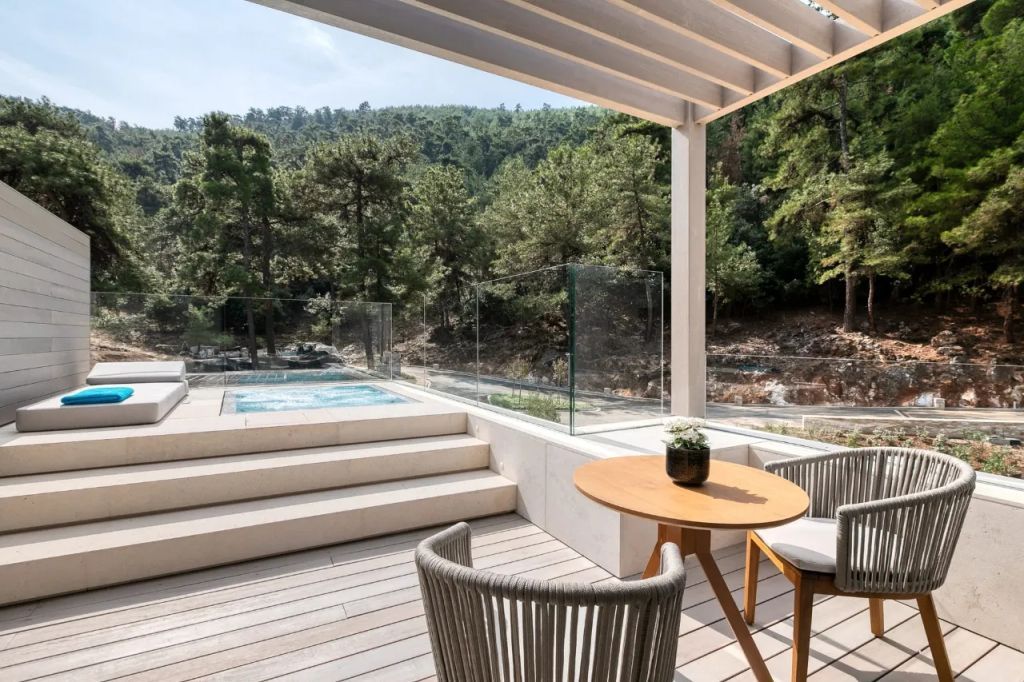 Terrasse mit Waldblick, Jacuzzi und gemütlichen Sitzgelegenheiten.