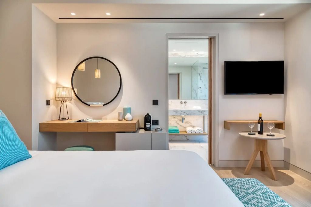Zimmeransicht mit Bett und Blick ins Badezimmer, moderne Einrichtung