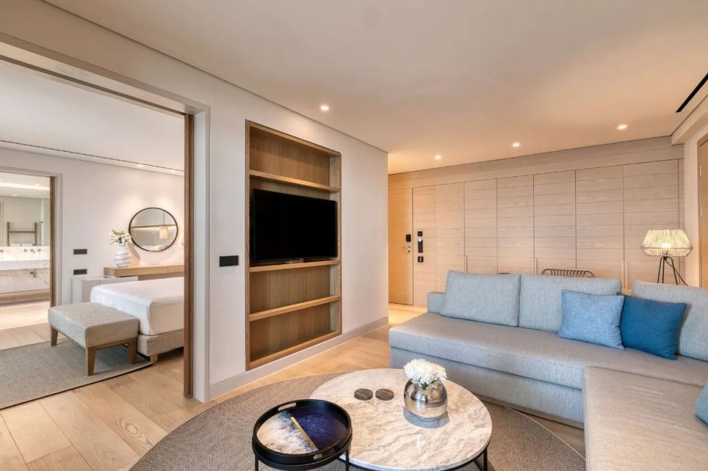 Luxuriöses Wohnzimmer mit Sofa, Fernseher und Zugang zum Schlafzimmer