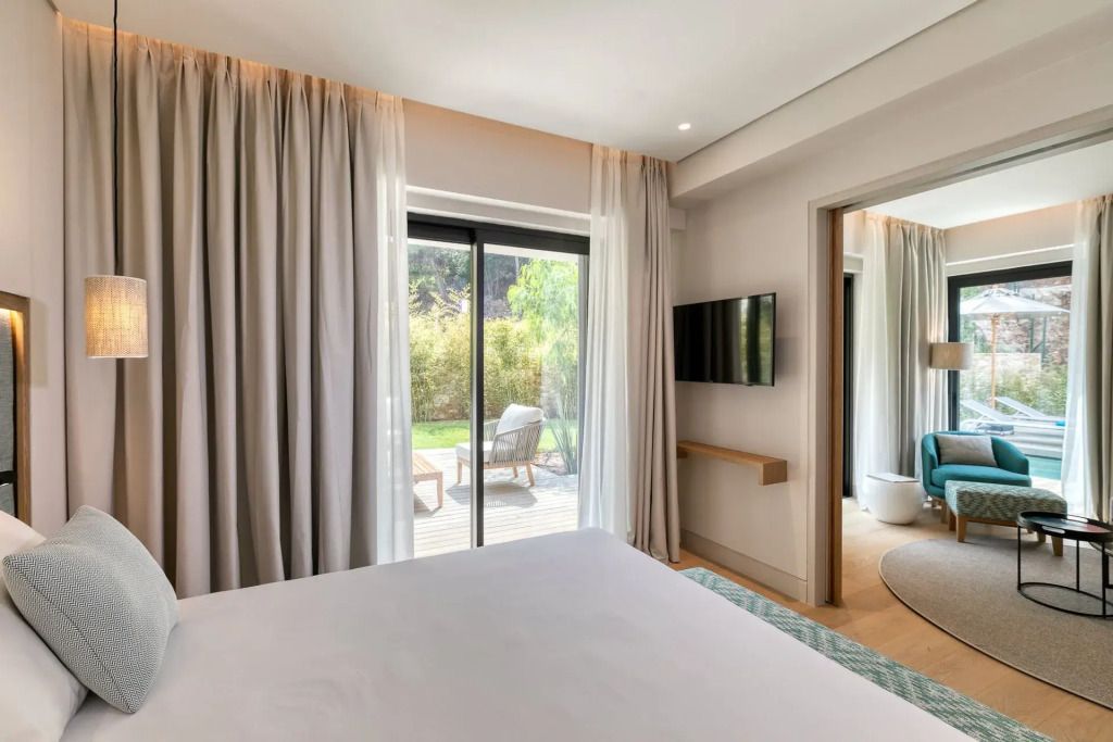 Schlafzimmer mit großen Fenstern und Blick auf Terrasse und Garten