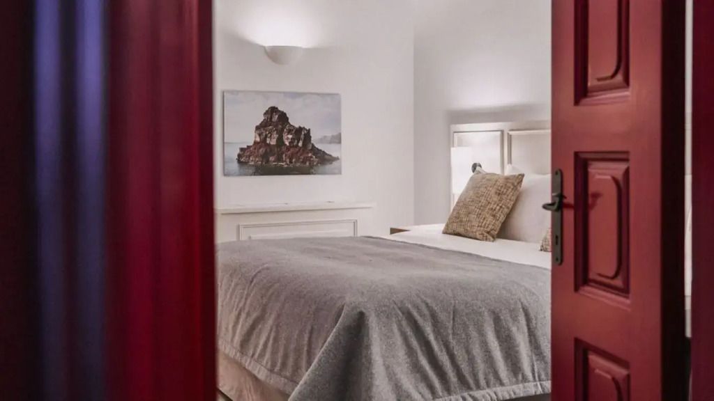 Helles Schlafzimmer mit gemütlichem Doppelbett und Kunstwerk eines Felsens.