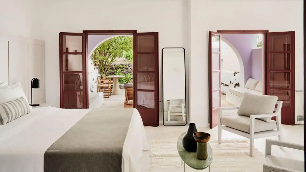 Schlafzimmer mit Zugang zu einer Terrasse mit Blick auf einen grünen Innenhof
