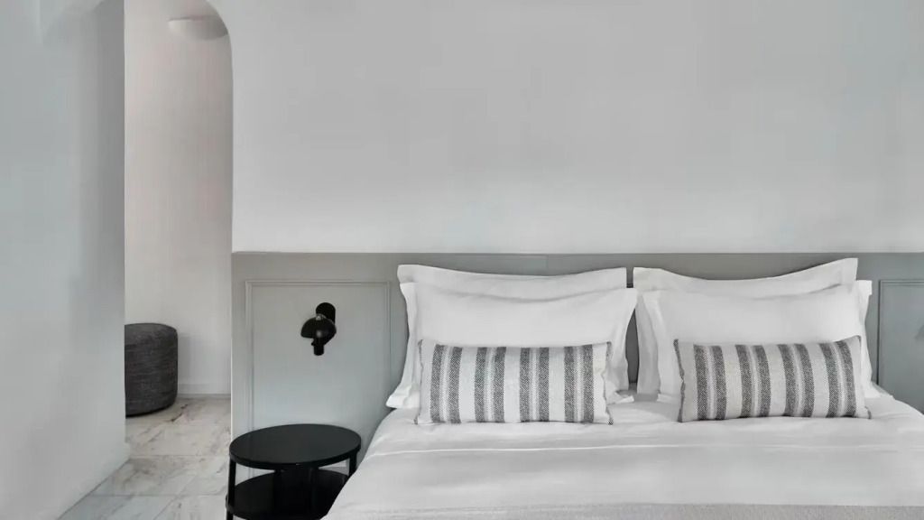 Nahaufnahme des Bettes in der Athenian Suite mit eleganten Kissen und seitlichem Nachttisch