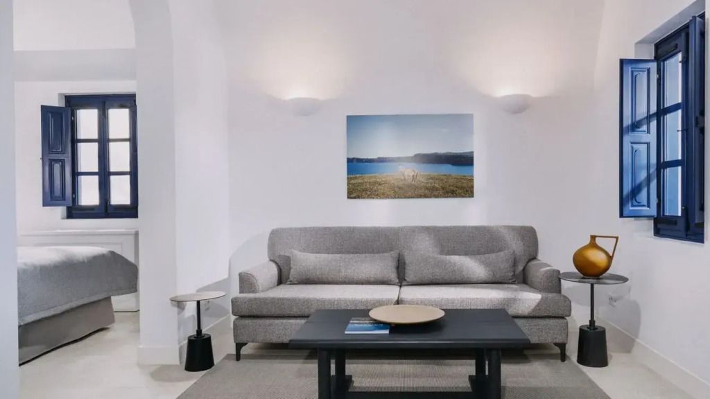 Elegante Sitzecke mit grauem Sofa und stilvollem Wandbild in der Corinthian Villa