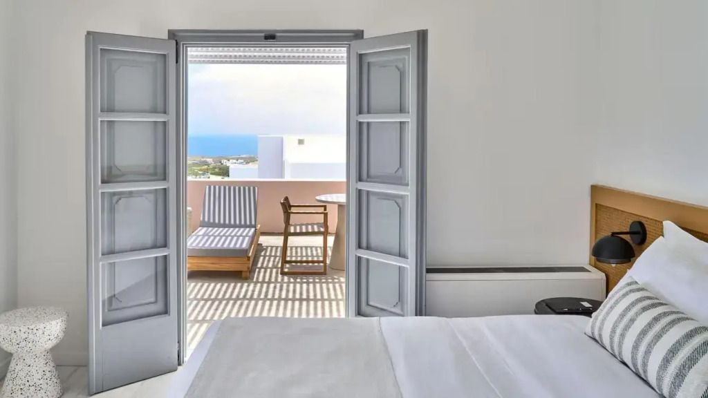 Blick von der Suite auf die Terrasse mit Meerblick und Liegestühlen