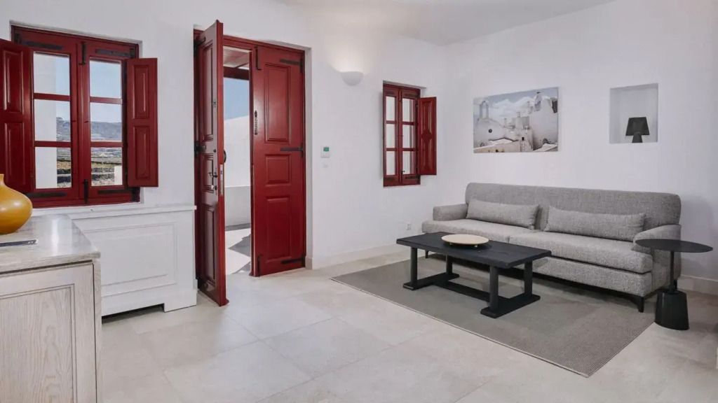 Wohnzimmer mit offener Tür zum Balkon, roter Türrahmen und stilvolle Einrichtung