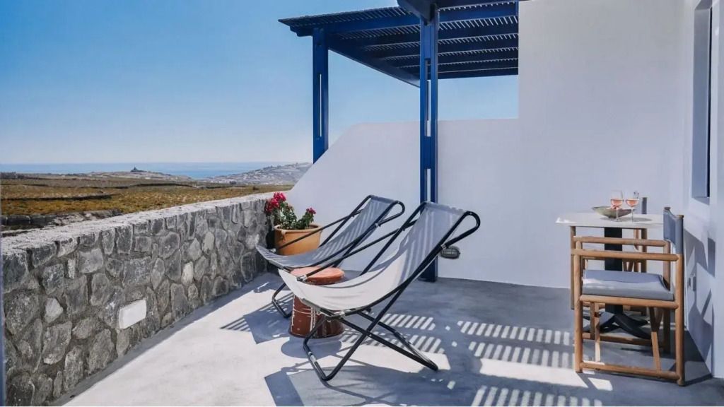 Entspannungsbereich auf der Terrasse mit Liegestuhl und Blick aufs Meer.