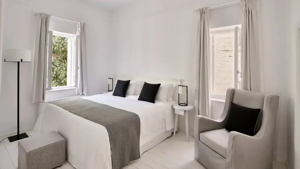 Helles Schlafzimmer mit Doppelbett, weißen Möbeln und grauen Akzenten