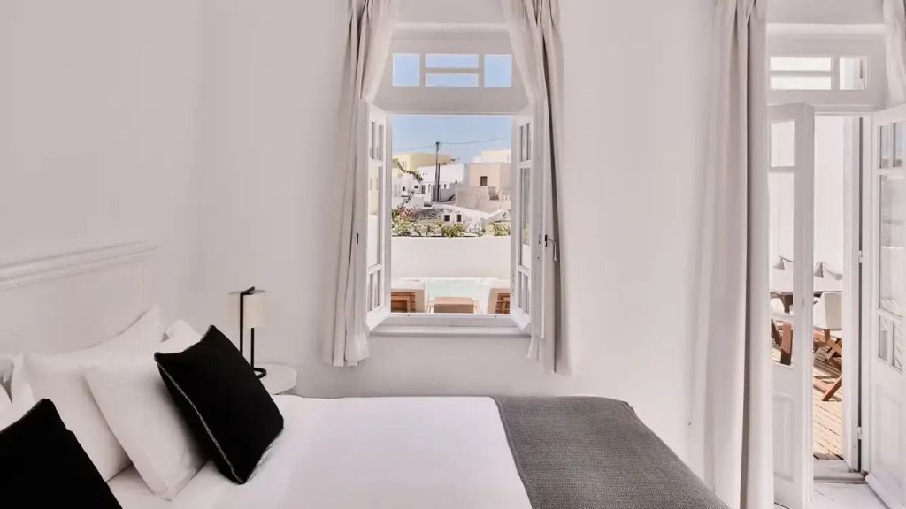Blick aus dem Fenster auf Santorinis Architektur von einem Schlafzimmer aus