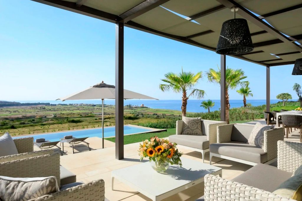 Terrasse mit Sitzgelegenheiten und Aussicht auf das Meer
