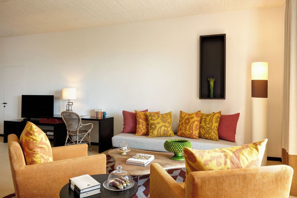 Wohnbereich mit bunter Couch und Schreibtisch in der Junior-Suite