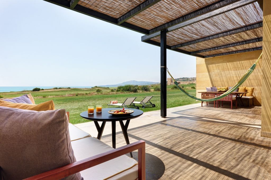 Große Terrasse mit Sitzmöbeln und Ausblick auf die grüne Landschaft.