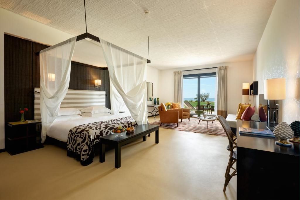 Geräumige Suite mit Himmelbett, eleganten Möbeln und Meerblick