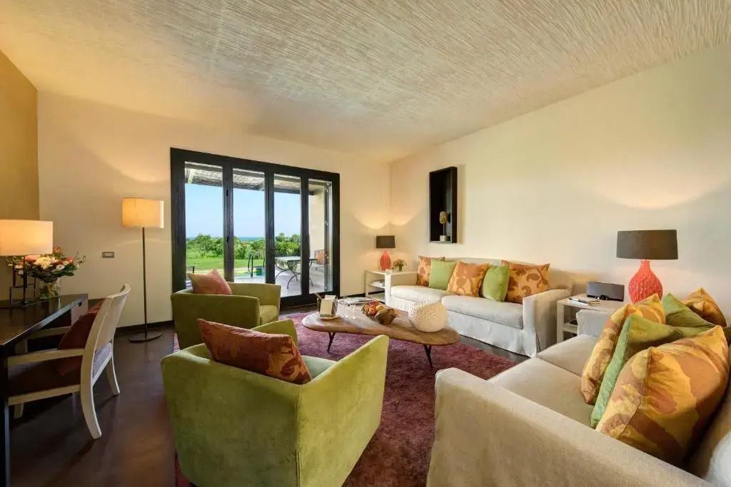 Heller Wohnraum mit Sofas und Panoramafenstern mit Gartenblick