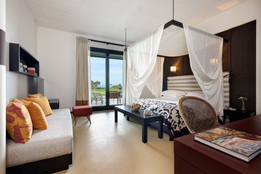 Elegantes Doppelzimmer im Verdura Resort mit Himmelbett und Blick auf den Garten