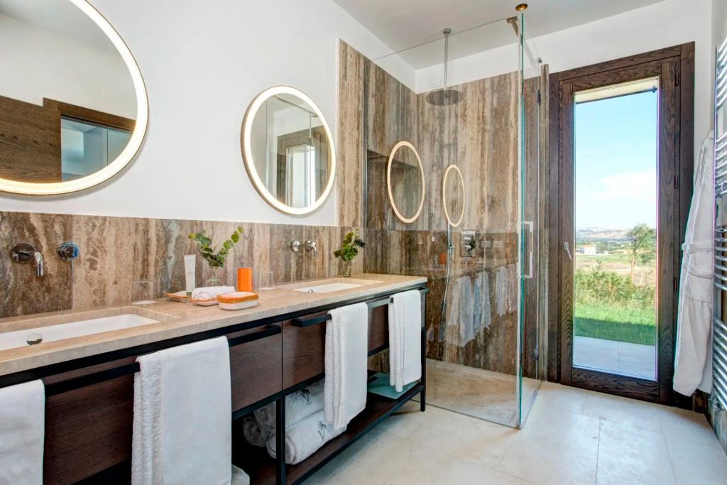 Luxuriöses Badezimmer mit Doppelwaschbecken und verglaster Dusche in der Topazio Villa.