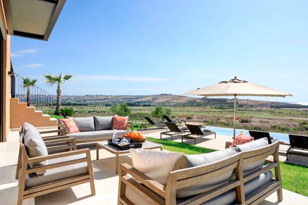 Terrasse mit komfortablen Sitzgelegenheiten. Blick auf die Landschaft und den Pool.