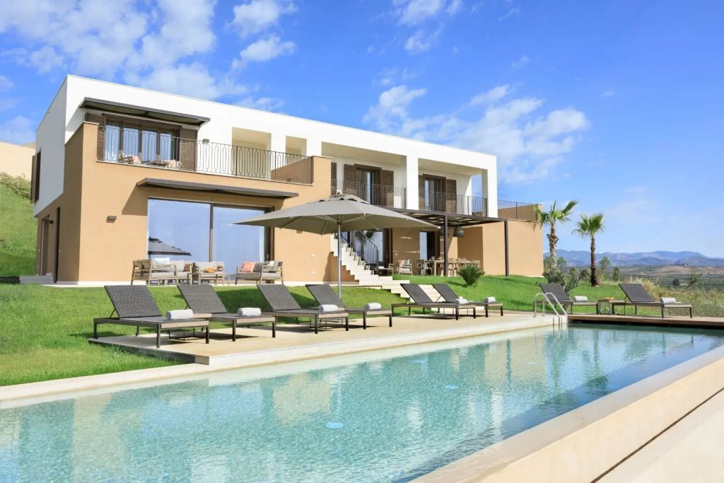 Exterieur der Topazio Villa mit privatem Infinity-Pool und Sonnenliegen.
