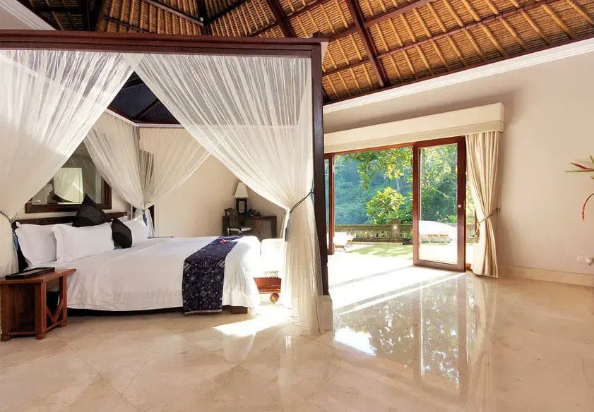 Helles Schlafzimmer in der Elephant Pool Villa mit Himmelbett und großem Fenster.
