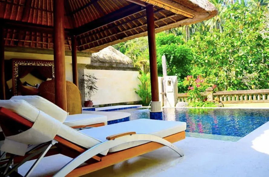 Privater Pool und Sonnenliegen in der Gartenanlage der Garden Pool Villa mit üppiger Vegetation.