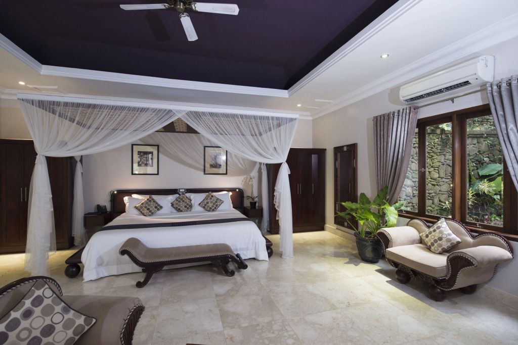Elegante Suite mit Himmelbett, Deckenventilator und edlen Holzmöbeln im Viceroy Bali.
