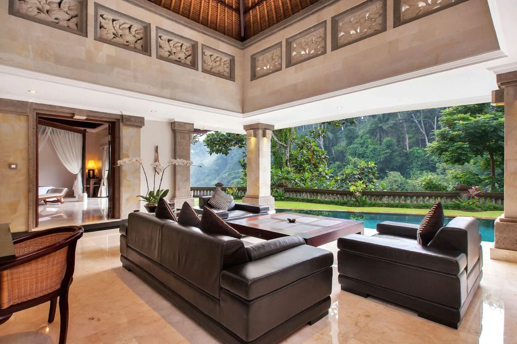 Offener Wohnbereich mit eleganten Sofas und Blick auf den tropischen Garten.