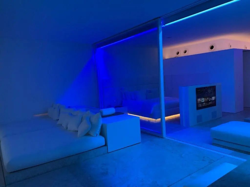 Modernes Hotelzimmer mit blauem LED-Licht und futuristischem Design.
