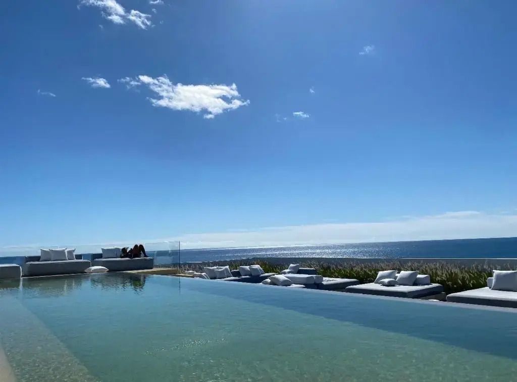 Infinity Pool mit Blick auf das Meer unter blauem Himmel