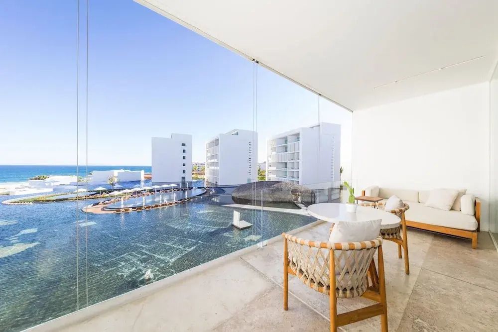 Sonnige Terrasse mit Blick auf modernes Design von Gebäude und Meer.