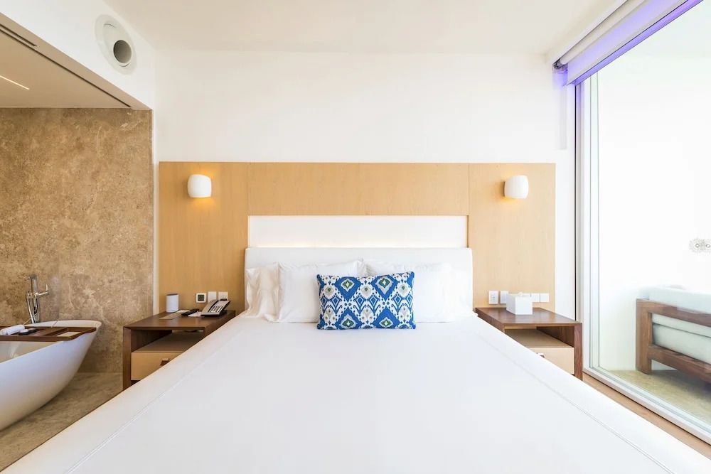 Helles Schlafzimmer mit großem Doppelbett und dekorativem Kissen