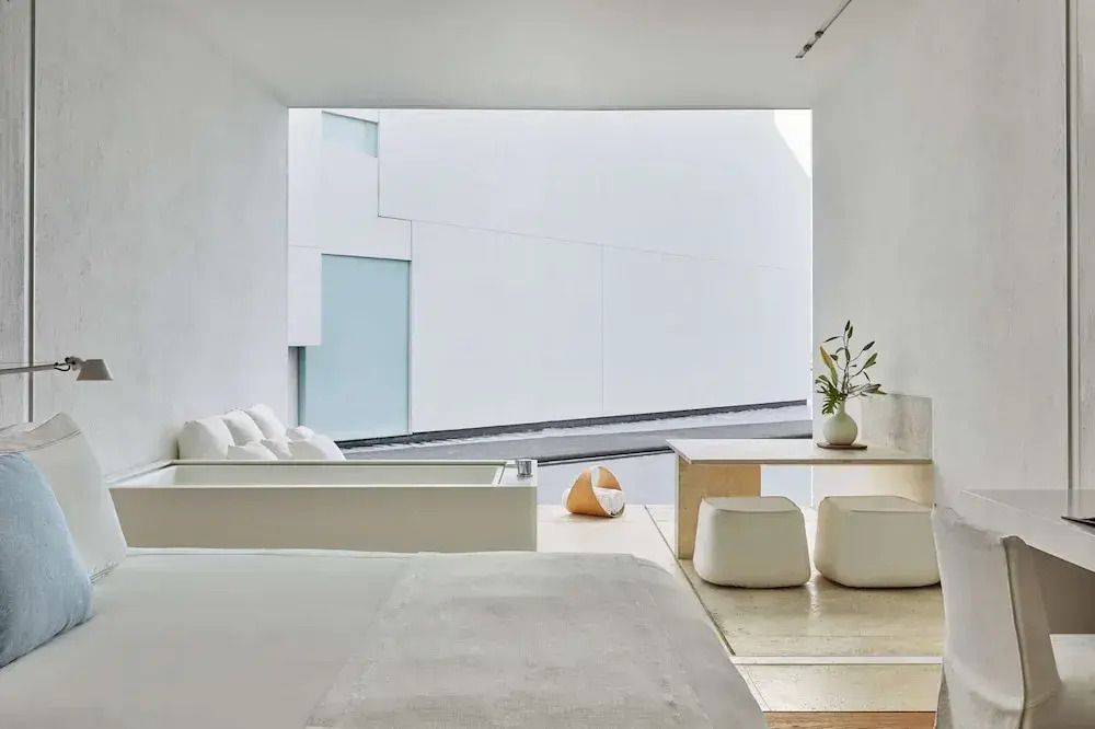 Minimalistisch gestaltetes Zimmer mit großen Fenstern und modernem Interieur