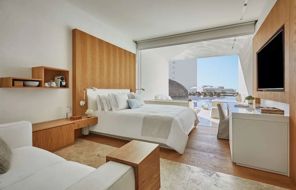 Helles Zimmer mit Doppelbett, Holzdetails und Blick auf das Meer