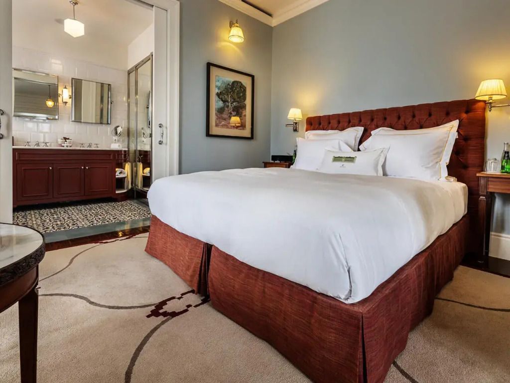 Elegantes Doppelbett in Junior-Suite mit stilvoller Einrichtung und Blick ins Badezimmer