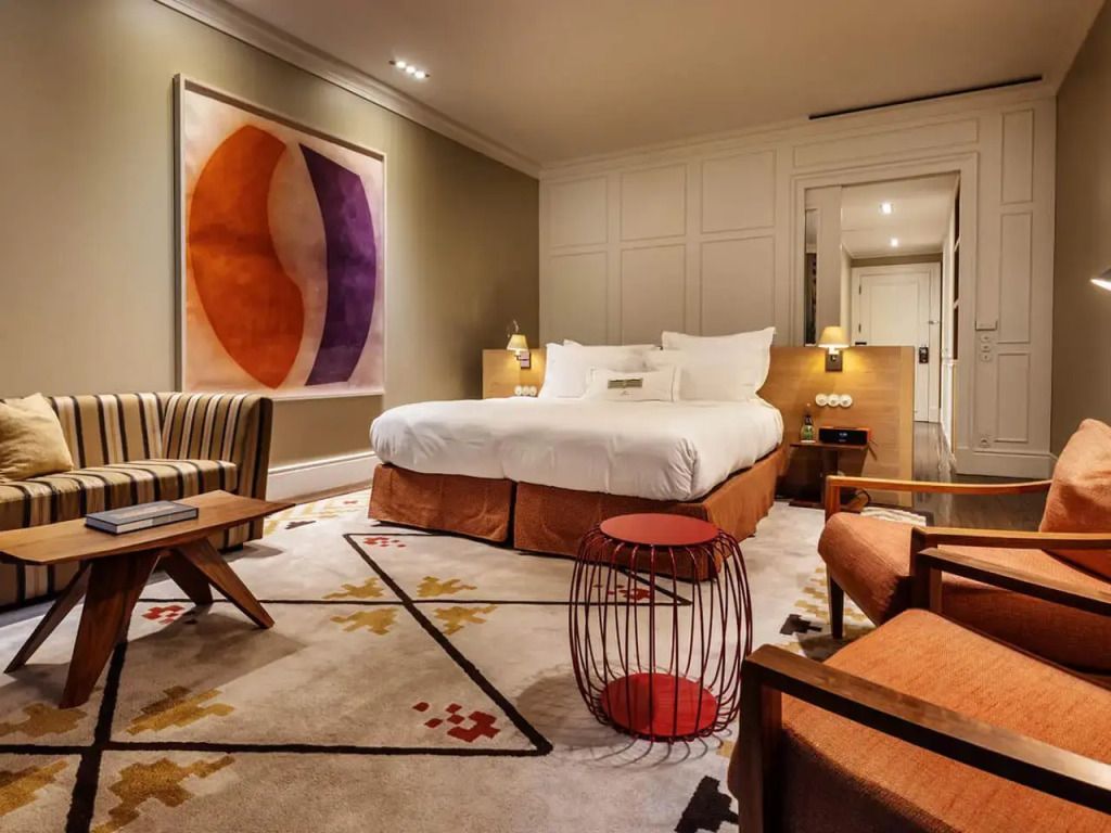 Elegant eingerichtetes Garden Deluxe Doppelzimmer mit farbenfrohem Kunstwerk an der Wand.