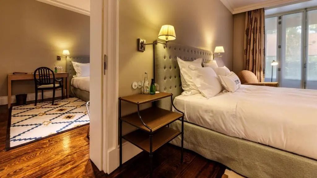 Doppelbett im geschmackvollen Interieur des Garden Zimmers mit Holzfußboden im Hotel Vidago Palace