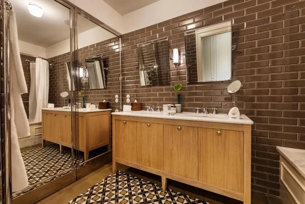 Modernes Badezimmer mit Holzschränken und großen Spiegeln im Hotel Vidago Palace