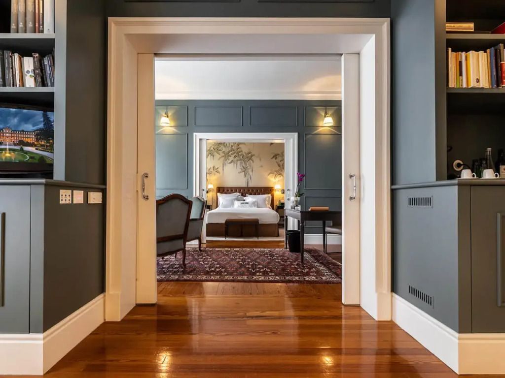 Flur führt in ein elegantes Schlafzimmer mit Sitzbereich und gedämpftem Licht
