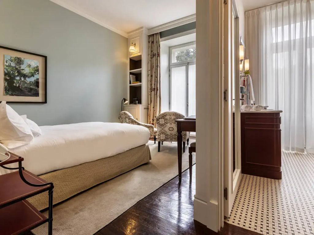 Gut beleuchtetes Zimmer mit Doppelbett, Sofa und großem Fenster