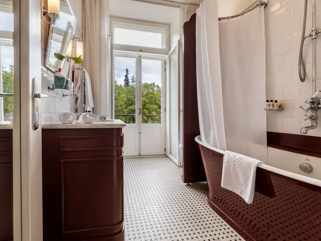 Edles Badezimmer mit Badewanne und Blick auf den Garten