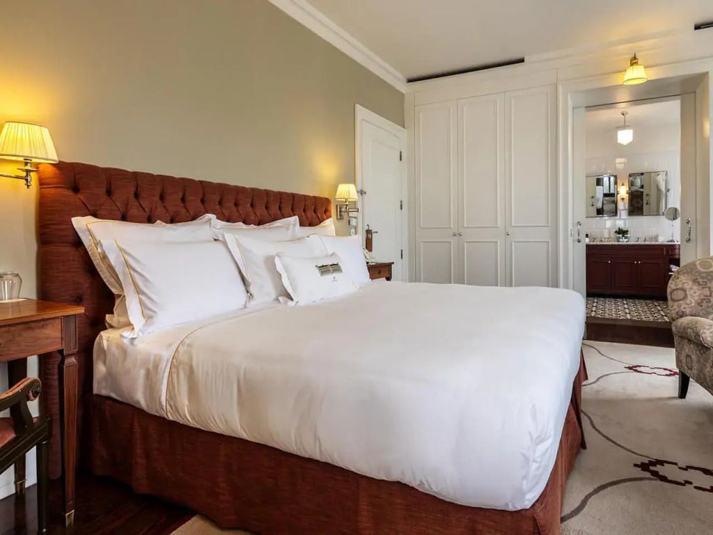 Luxuriöses Schlafzimmer mit Doppelbett und eleganter Bettwäsche im Vidago Palace Hotel