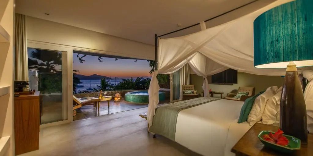 Deluxe Doppelzimmer mit Himmelbett und Meerblick bei Sonnenuntergang