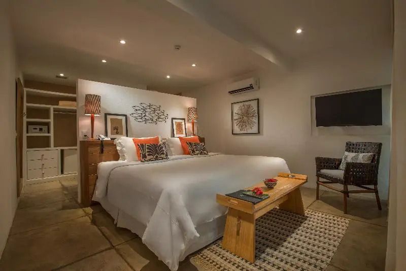 Komfortables Doppelbett in Zimmer mit eleganter Wandkunst und Holzmöbeln.