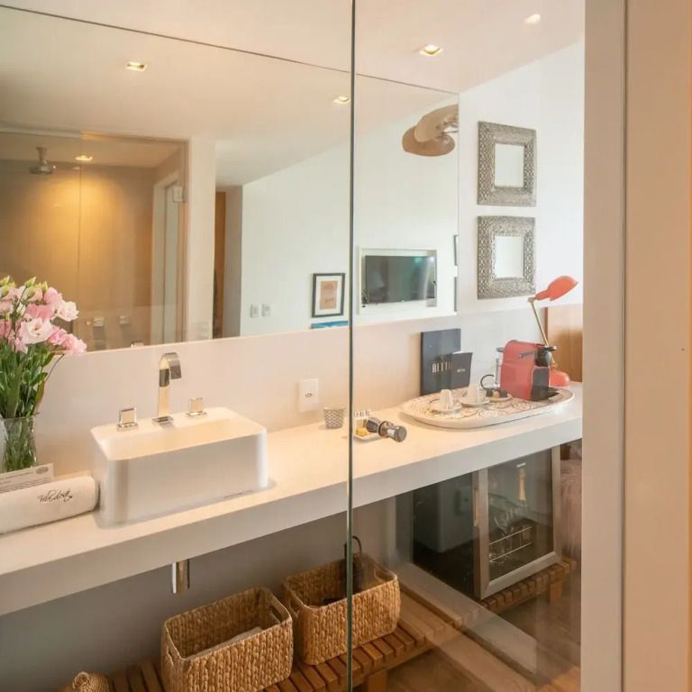 Modernes Badezimmer mit großzügigem Spiegel und eleganter Dekoration.