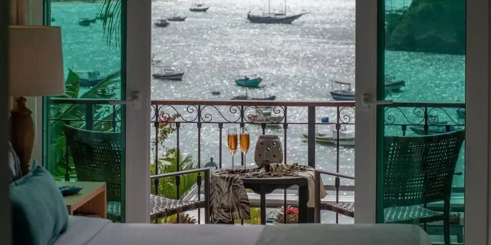 Balkonaussicht auf das Meer mit Tisch und Gläsern bereit für romantische Momente.
