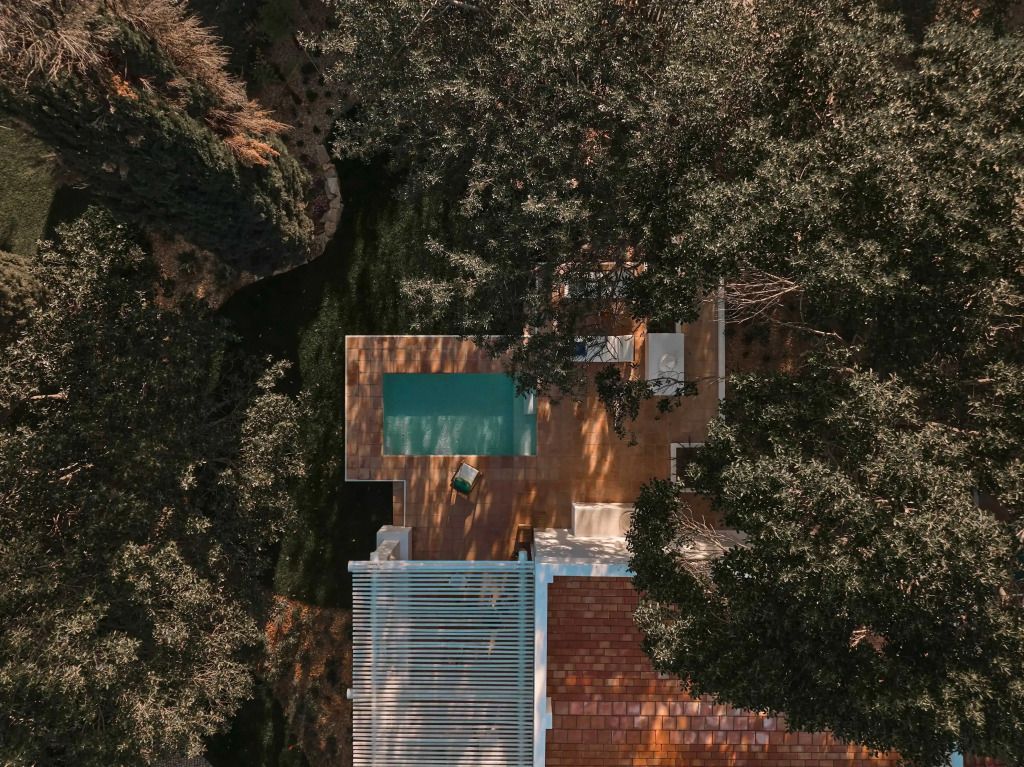 Kleiner Pool auf einer Terrasse, umgeben von üppiger Vegetation