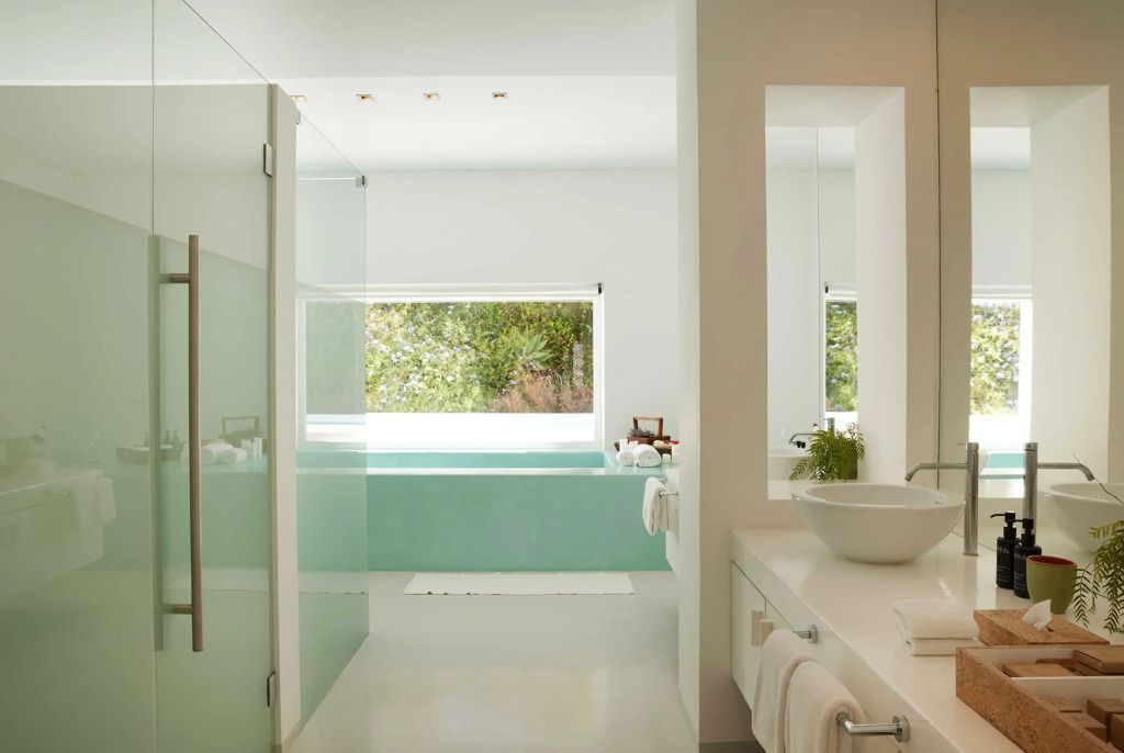 Modernes Badezimmer mit großer Wanne vor einem Fenster und Naturblick