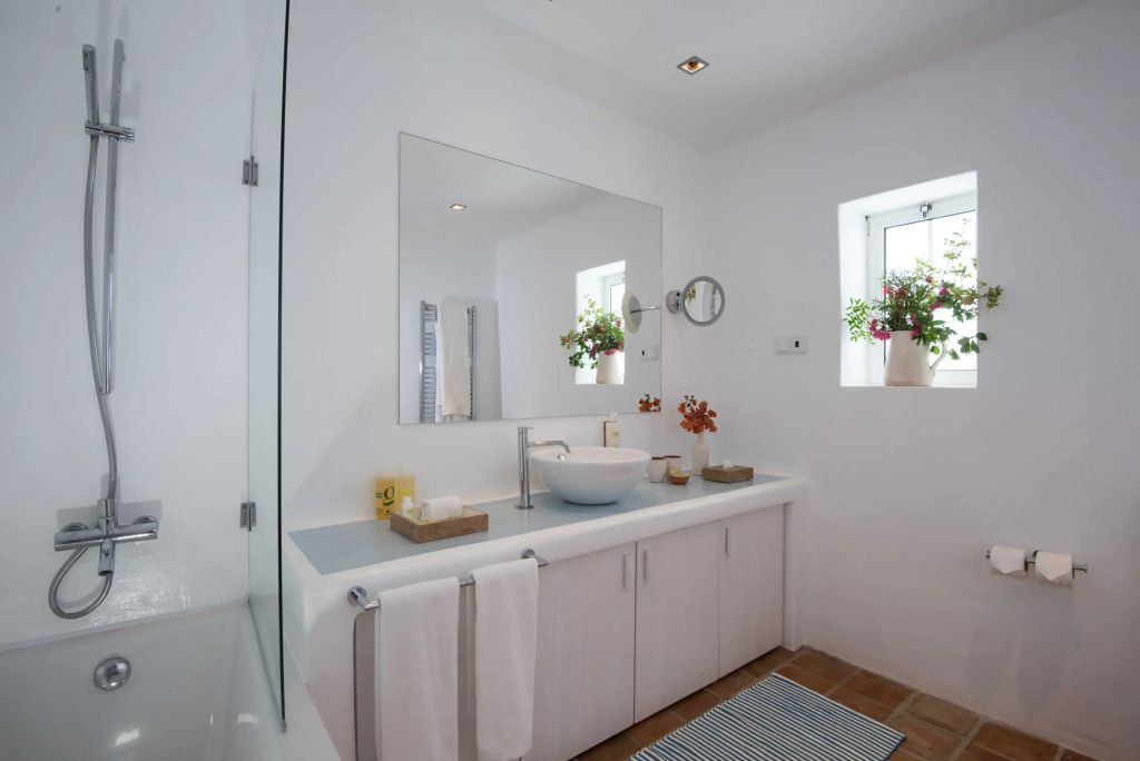 Modernes Badezimmer mit Spiegel und dekorativen Pflanzen im Octant Vila Monte