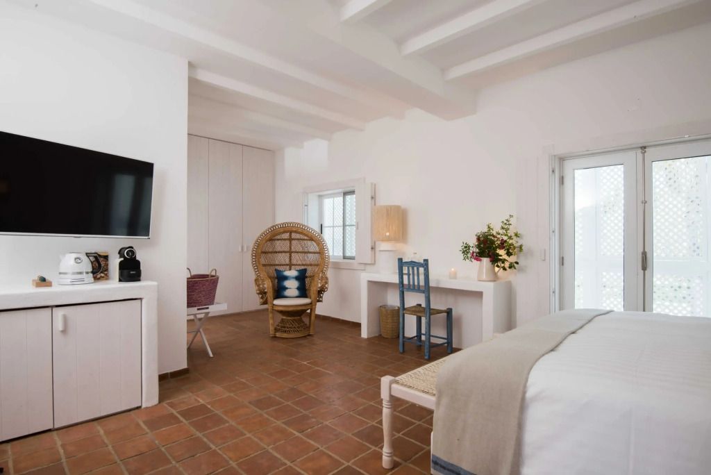 Geräumiges Zimmer mit Fernseher, Sitzbereich und Schreibtisch im Octant Vila Monte