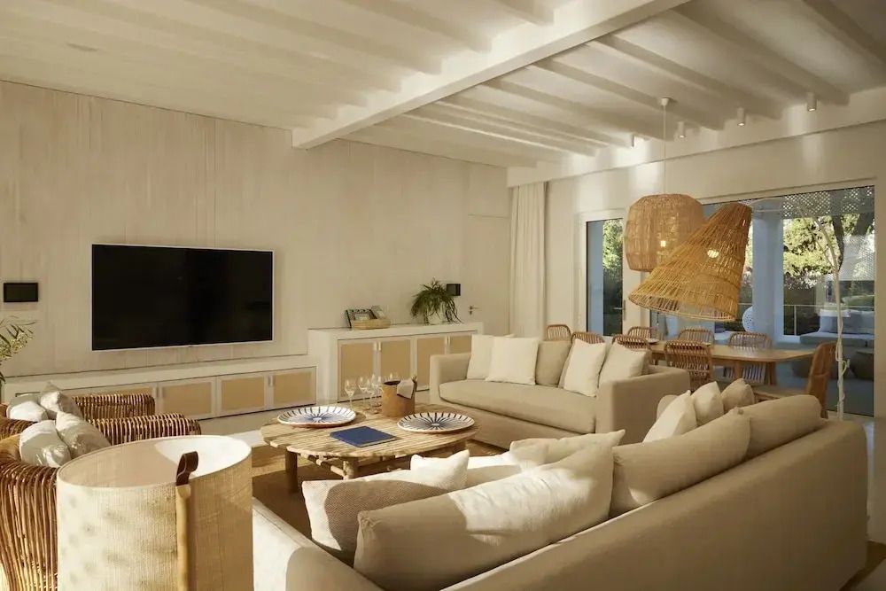 Geräumiges Wohnzimmer mit Sofas und großem Fernseher