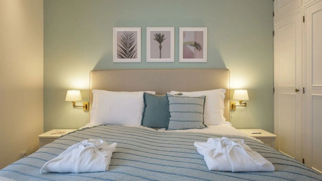 Elegantes Schlafzimmer mit Kunst an der Wand und gemütlichem Bett.